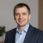 Портрет уверенного российского бизнесмена в студийном освещении на размытом нейтральном фоне для сайта